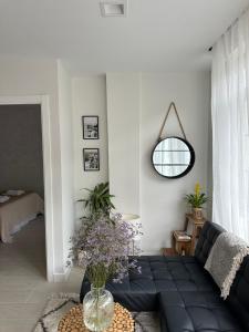 a living room with a black couch and a mirror at Casa Amodiño in Belesar