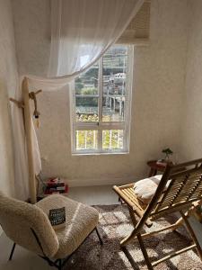 een kamer met een bed, een stoel en een raam bij Casa Amodiño in Belesar