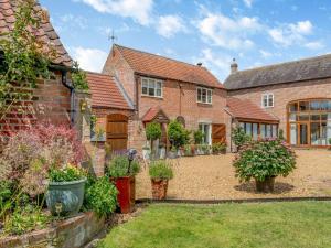 Paddock Cottage - Thorpe Arnold Melton Mowbray في ميلتون موبراي: اطلالة خارجية على منزل مع حديقة