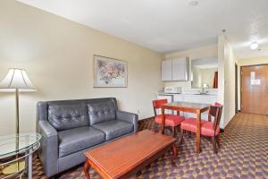 een woonkamer met een bank en een tafel bij Geneva Motel Inn in Saint Charles