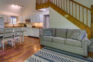 ein Wohnzimmer mit einem Sofa und einem Tisch sowie eine Küche in der Unterkunft Cozy Bainbridge Retreat with Fireplace and Deck! 