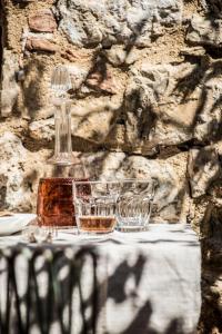 butelka i dwie szklanki siedzące na stole w obiekcie Agriturismo I Pini w mieście San Gimignano