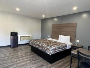 a hotel room with a bed and a table and chair at Sunshine Motel in Long Beach