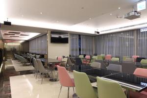 Sala de conferencias con mesas, sillas y TV en Royal Jade Boutique Hotel en Taipéi