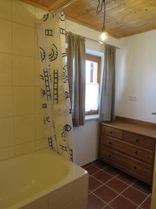 a bathroom with a bath tub and a window at Haus Erle in Peiting