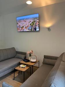 sala de estar con 2 sofás y TV en la pared en Dom nad Stryszawką z SAUNĄ - domek wypoczynkowy, en Stryszawa
