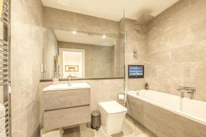 a bathroom with a toilet and a sink and a tub at Modern Apartments in Vibrant Ramsgate in Kent