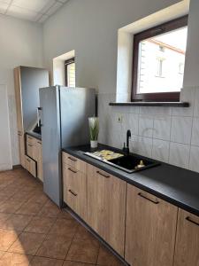 a kitchen with a sink and a refrigerator at Pokoje Komfort in Szypliszki