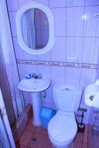 a small bathroom with a toilet and a sink at Naty's Guest House in Cusco