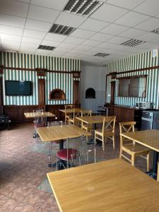 a dining room with tables and chairs and a tv at Pokoje Komfort in Szypliszki