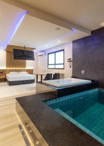 uma casa de banho com uma piscina, uma cama e uma banheira em Drops Motel POA Zona Sul em Porto Alegre