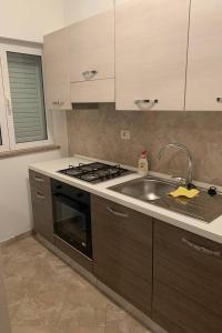 uma cozinha com um lavatório e um fogão em Apartment Ivo Andric em Zadar