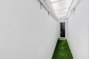 un corridoio con parete bianca e erba verde di Barcelona Beach Vibes a Sant Adrià de Besòs