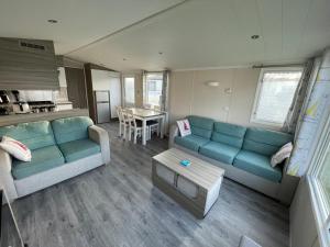 a living room with a couch and a table at Sea Breeze in Perranporth