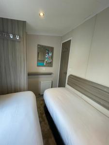 Habitación de hotel con 2 camas y ventana en Sea Breeze en Perranporth