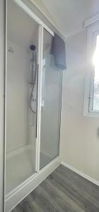 a glass shower stall in a room with a window at Sea Breeze in Perranporth