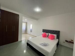 1 dormitorio con 1 cama con almohadas rosas en Alojamiento Yopal, en Yopal