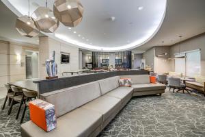 a lobby with a long couch and a bar at SpringHill Suites Gainesville in Gainesville