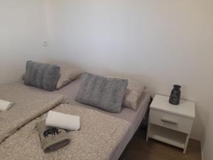 een bed met 2 kussens en een nachtkastje in een kamer bij Tiny House Lily with jacuzzi in Sveti Filip i Jakov