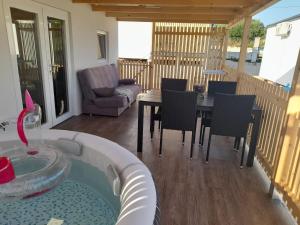 a living room with a table and chairs and a tub at Tiny House Lily with jacuzzi in Sveti Filip i Jakov +32 photos