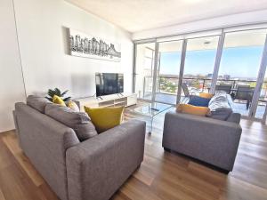 uma sala de estar com dois sofás e uma televisão em Oxygen Apartments em Brisbane
