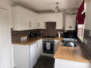 a kitchen with white cabinets and a sink at House number 12 sleeps up to 5 with Smart TVs in every room in Wellington