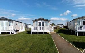 a row of mobile homes on a lawn at Bordeaux - Church Farm in Pagham