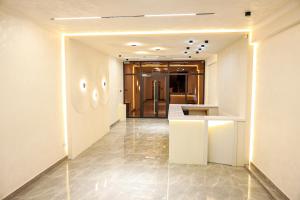 a hallway of a building with white walls and a counter at Hotel Borjomi in Shymkent