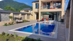 uma casa com piscina em frente a uma casa em Villa Star em Gabala