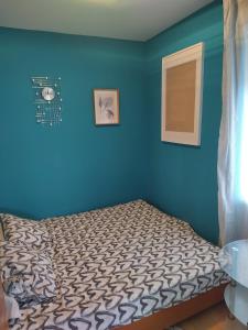 a bedroom with a bed with a blue wall at STUDIO APARTMAN KARLER in Karlovac