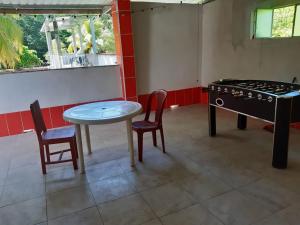 a room with a table and chairs and a stove at Chalet El Paraiso in Escuintla