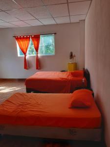 1 dormitorio con 2 camas y ventana en Chalet El Paraiso, en Escuintla