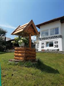 una estructura de madera frente a una casa en Casa M.A.R.A en Corbeni