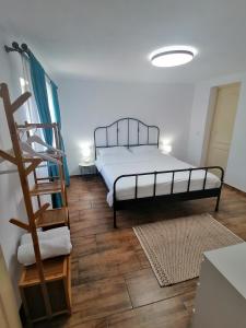 um quarto com uma cama e piso em madeira em Casa M.A.R.A em Corbeni