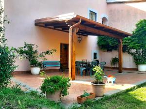 a patio with a wooden pergola and a table at Agrihouse in Bracciano