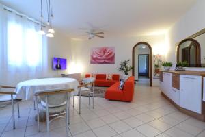 uma cozinha e sala de estar com uma mesa e um sofá em Rosalinde House em Colà di Lazise
