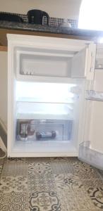 an open refrigerator with a bottle of wine in it at Cosy apartment in popular harbour town in Kirkcudbright