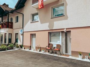 a building with two chairs and a table on the porch at Apartments Ivanović in Idrija