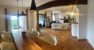 een woonkamer met een houten tafel en stoelen bij Villa de charme piscine et jacuzzi 190 m2 in Mouans-Sartoux