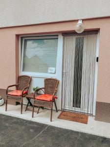 two wicker chairs sitting on a porch next to a window at Apartments Ivanović in Idrija