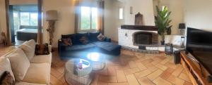een woonkamer met een bank en een open haard bij Villa de charme piscine et jacuzzi 190 m2 in Mouans-Sartoux