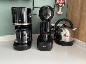 a black coffee maker and a tea kettle on a counter at Ty Breizh in Saint-Nic