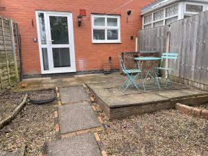 a patio with a table and chairs in front of a house at House number 12 sleeps up to 5 with Smart TVs in every room in Wellington