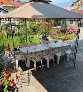 einen Tisch und Stühle unter einem Sonnenschirm in einem Garten in der Unterkunft Gjorgji Apartments 68a in Ohrid