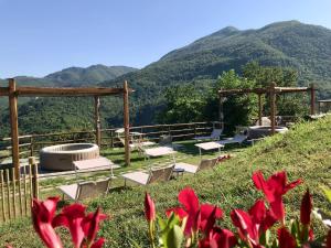 un gruppo di sedie su una collina con montagne sullo sfondo di La Beppa - Casa Vacanza a Pontremoli