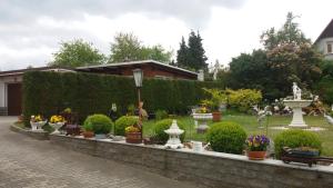 a garden with flowers and vases on a wall at Ferienwohnung ILSENHOF in Königsbrück