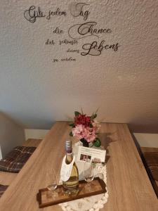 einen Tisch mit einer Flasche Wein und Gläsern in der Unterkunft Ferienwohnung ILSENHOF in Königsbrück