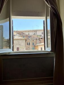 an open window with a view of a city at L'attico del 1600 in centro in Perugia