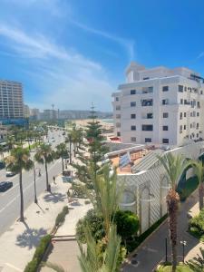 a view of a city with palm trees and a building at Appartement En Bord de Mer in Tangier