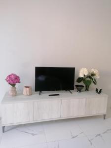 a white living room with a tv on a white table at Roero Sunset in Govone